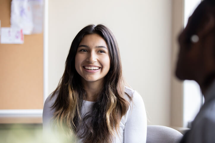 happy young woman talking to her psychiatrist 