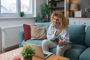 Young woman talking on video call with her telehealth psychiatrist during her online therapy sessions.