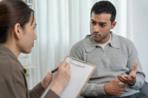 Man explain mental health problems to a female psychiatrist during psychiatric evaluation bipolar disorder.