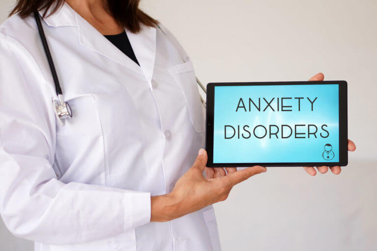 Anxiety disorders written on medical digital tablet with a female doctor.